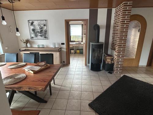 a living room with a table and a wood stove at Ferienhaus Windrödel in Herzhausen