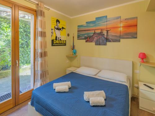 a bedroom with a blue bed with two towels on it at EnjoyIseoLake - Blooming Lakefront in Fonteno