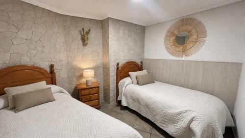 a bedroom with two beds and a mirror on the wall at Apartamento La Plaza! in Bogarra
