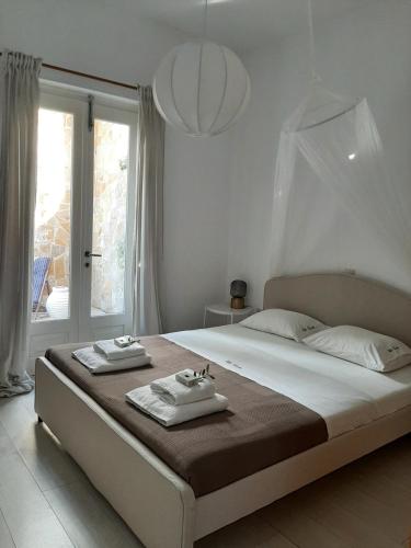 a bedroom with a large bed with towels on it at Guesthouse Cato in Vátos