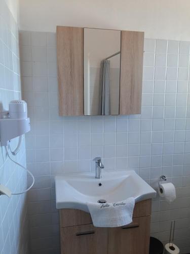 a bathroom with a white sink and a mirror at Guesthouse Cato in Vátos