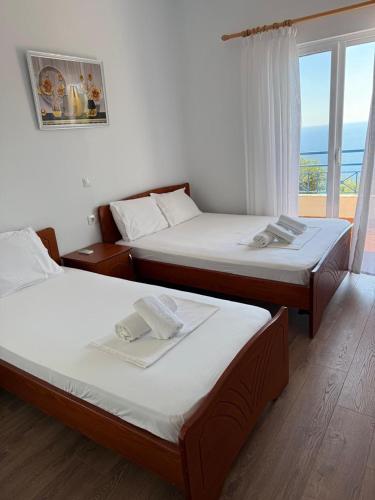 two beds in a room with a view of the ocean at Guesthouse Mili in Piqeras