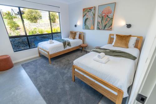 two beds in a room with two windows at The Valley Lodge in Yallingup