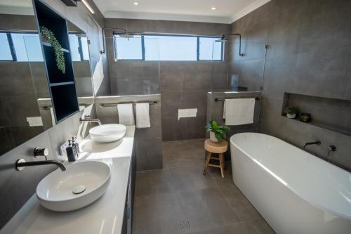 a bathroom with a tub and a sink and a bath tub at The Valley Lodge in Yallingup