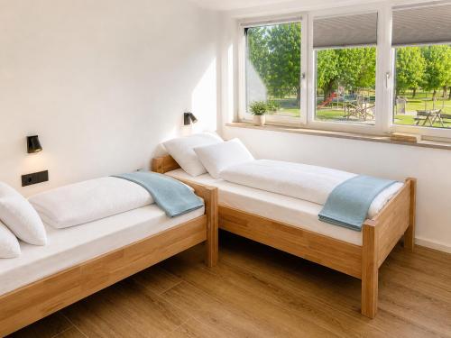 two beds in a room with two windows at Hafenapartments Segelschule Mondsee in Mondsee