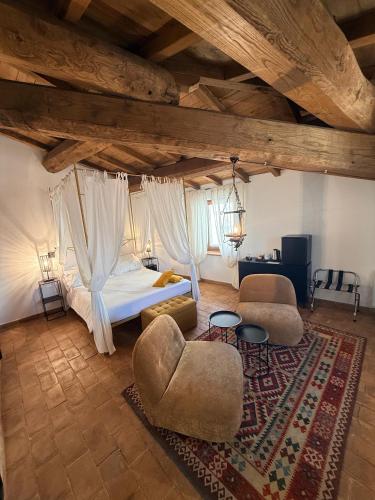 a bedroom with a bed and two chairs and a rug at Claustrum di Colforcella in Cascia