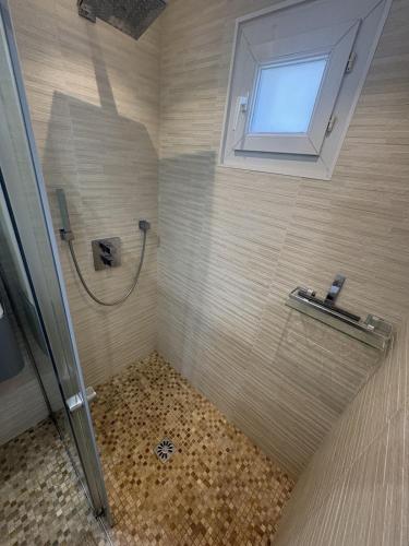 a bathroom with a shower and a window at T2 design climatisé au coeur de Divonne in Divonne-les-Bains
