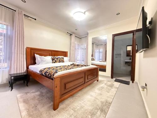 a bedroom with a large bed and a bathroom at Gono Retreat Four bedroom in Kisumu