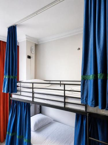 a bedroom with two bunk beds with blue curtains at Smash Hostel Batumi in Batumi