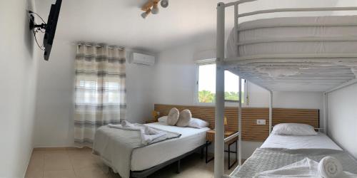 a bedroom with two bunk beds and a window at Casa los Pinos Calpe Playa in Calpe