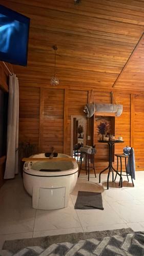 a large bathroom with a tub and a table at Cabana Zanetti in Santa Teresa