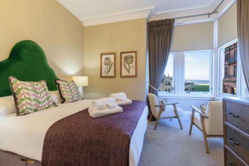 a hotel room with a bed with towels on it at 20 Golf Place in St. Andrews