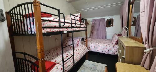 a bedroom with two bunk beds with pink sheets at Meyenburg Family Room in Mount Morgan