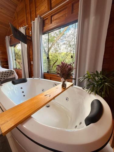 a bath tub in a room with a window at Cabana Zanetti in Santa Teresa