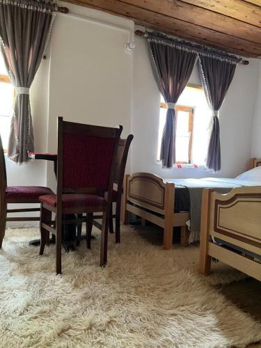 a bedroom with a table and chairs and a bed at Guesthouse Kujtimi in Theth