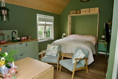 a bedroom with a bed and a table and chairs at Theetuin en B & B 'De Theetuin' in Wijckel