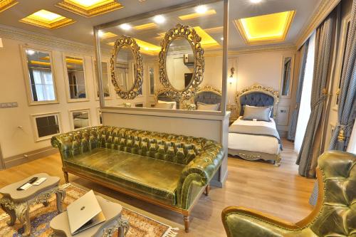 a bedroom with a couch and a bed and mirrors at REAL KiNG SUiTE in Trabzon