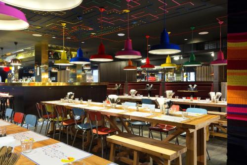 a restaurant with wooden tables and chairs and colorful lights at RockyPop Chamonix - Les Houches in Les Houches