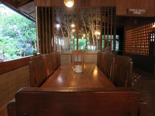 a wooden table in a restaurant with a cup on it at Kadidiri Paradise in Batudaka