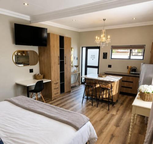 a bedroom with a bed and a kitchen with a table at Maison De Blom in Aliwal North