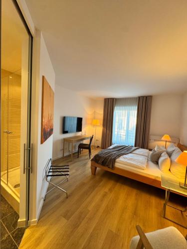 a bedroom with a bed and a desk in it at Plaza Rooms & Studios in Forchheim