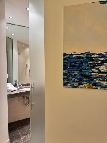 a bathroom with a painting on the wall at Plaza Rooms & Studios in Forchheim