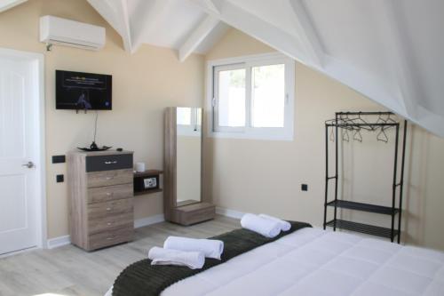 a bedroom with a bed and a dresser with a mirror at Zeus Cosmos Apartments in Lourdata