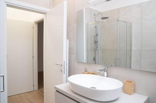 a white bathroom with a sink and a mirror at The Castle Apartment in Brescia