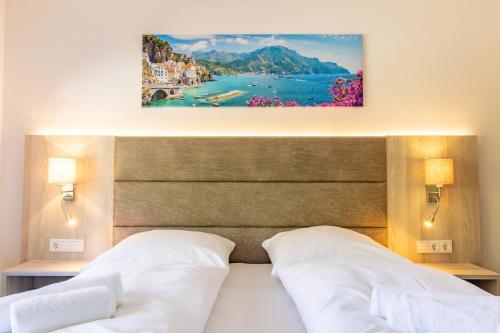 a bedroom with two beds and a painting on the wall at Lago Edera - Panoramablick in Hemfurth-Edersee