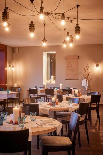 a dining room with tables and chairs and lights at Sorell Hotel Rigiblick - Studios & Spa Suites in Zürich