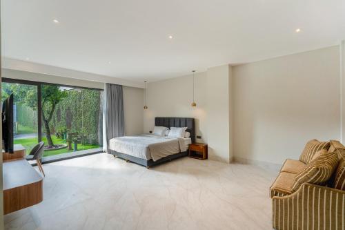 a bedroom with a bed and a large window at Villa 234 Yogyakarta in Yogyakarta