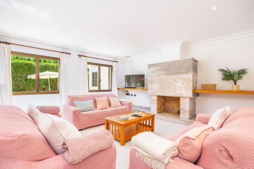 a living room with pink furniture and a fireplace at Llenaire Gran Beach House in El Port