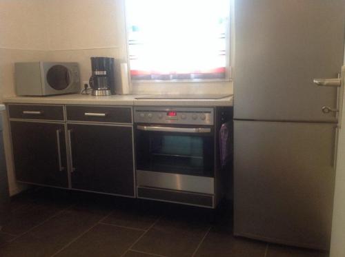 uma cozinha com um forno de aço inoxidável e um frigorífico em Ferienwohnungen Kolsdorf B em Braunlage