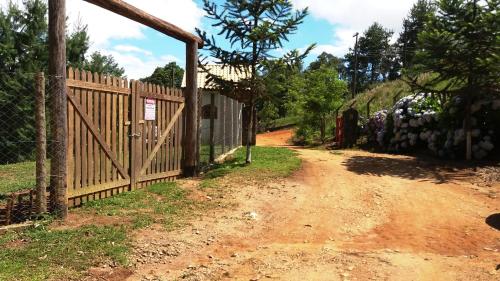 a fence on the side of a dirt road at Refúgio do Azzi in Monte Verde