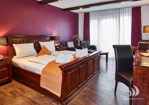 a bedroom with a bed with a desk and chairs at Riverside Hotel in Nordhorn