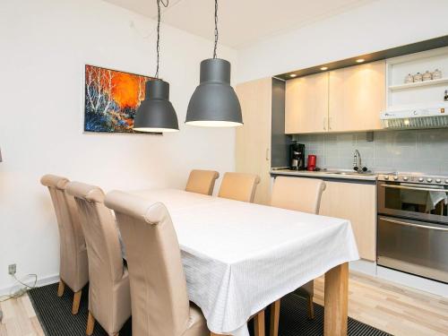 a kitchen and dining room with a white table and chairs at 4 person holiday home on a holiday park in Faaborg in Faaborg