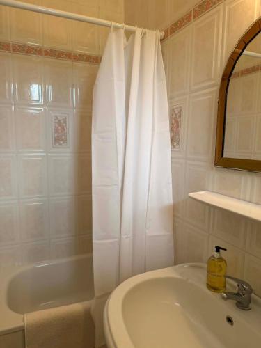 a bathroom with a sink and a shower curtain at Ágnes Nyaralóház in Siófok
