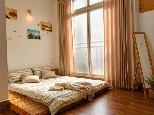 a bed in a room with a large window at 拉瓦宅 輕旅店 - Lawa House #僅接待18-35歲青年旅人#Only for aged 18-35 in Chiayi City