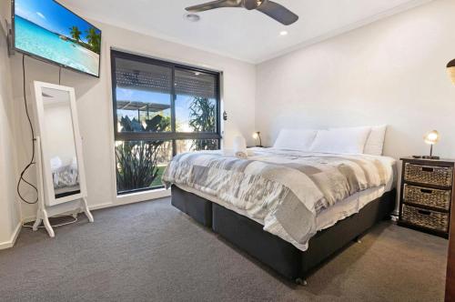 a bedroom with a large bed and a window at Maffra Retreat in Maffra