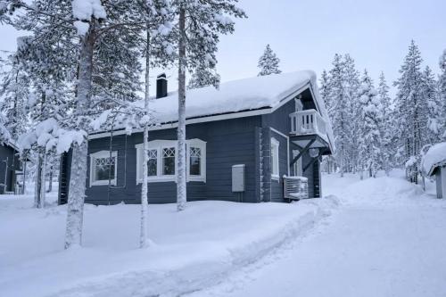 a log cabin in the snow with trees at Holiday Cabin Naalinpesä incl Wifi, outdoor jacuzzi for extra fee in Äkäslompolo