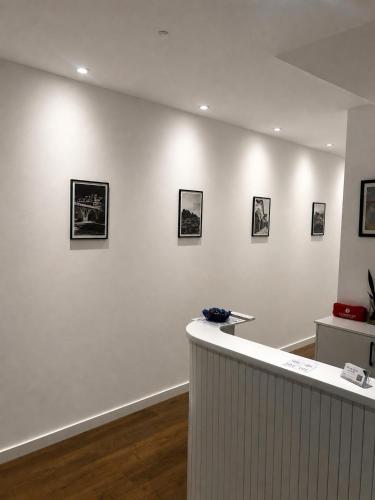 a room with a white wall with pictures on it at Villa Niku Berat in Berat