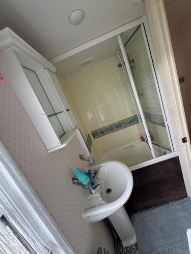 a small bathroom with a sink and a mirror at Home from home in Ingoldmells
