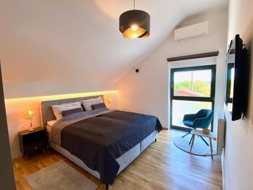 a bedroom with a bed and a window and a chair at Villa Colapis in Ozalj