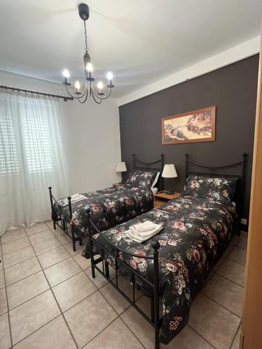 a bedroom with two beds and a table at B&B Pokerdassi in Leonforte