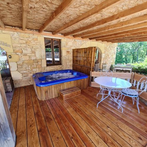 a large room with a hot tub and a table at Domaine du Cardou in Puy-lʼÉvêque