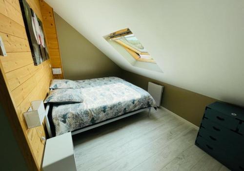 a small bedroom with a bed in a attic at Maison de pêcheur in Étretat