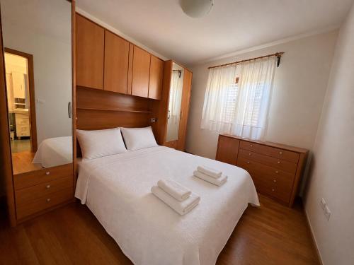 a bedroom with a white bed with two towels on it at Villa Nona with swimming pool in Dornberk