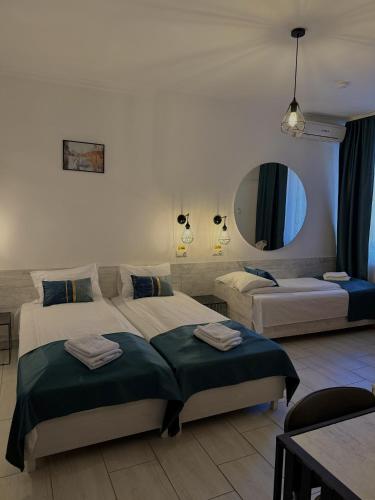 ein Hotelzimmer mit zwei Betten und einem Spiegel in der Unterkunft Pension Recidency in Oradea