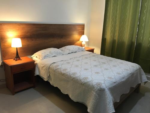 1 dormitorio con 1 cama grande y cabecero de madera en Hotel El Dorado Inn, en Camaná