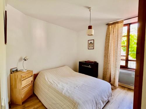 a bedroom with a bed and a window at Appartement minimaliste et cozy in Cajarc